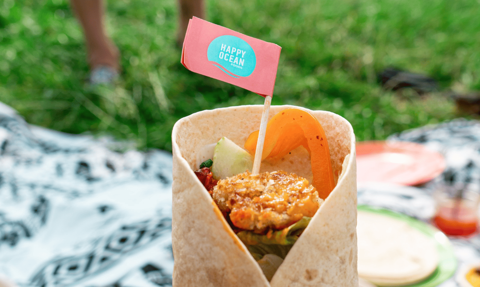 Wrap at a picknick with a fried shrymp and a branded Flag on top