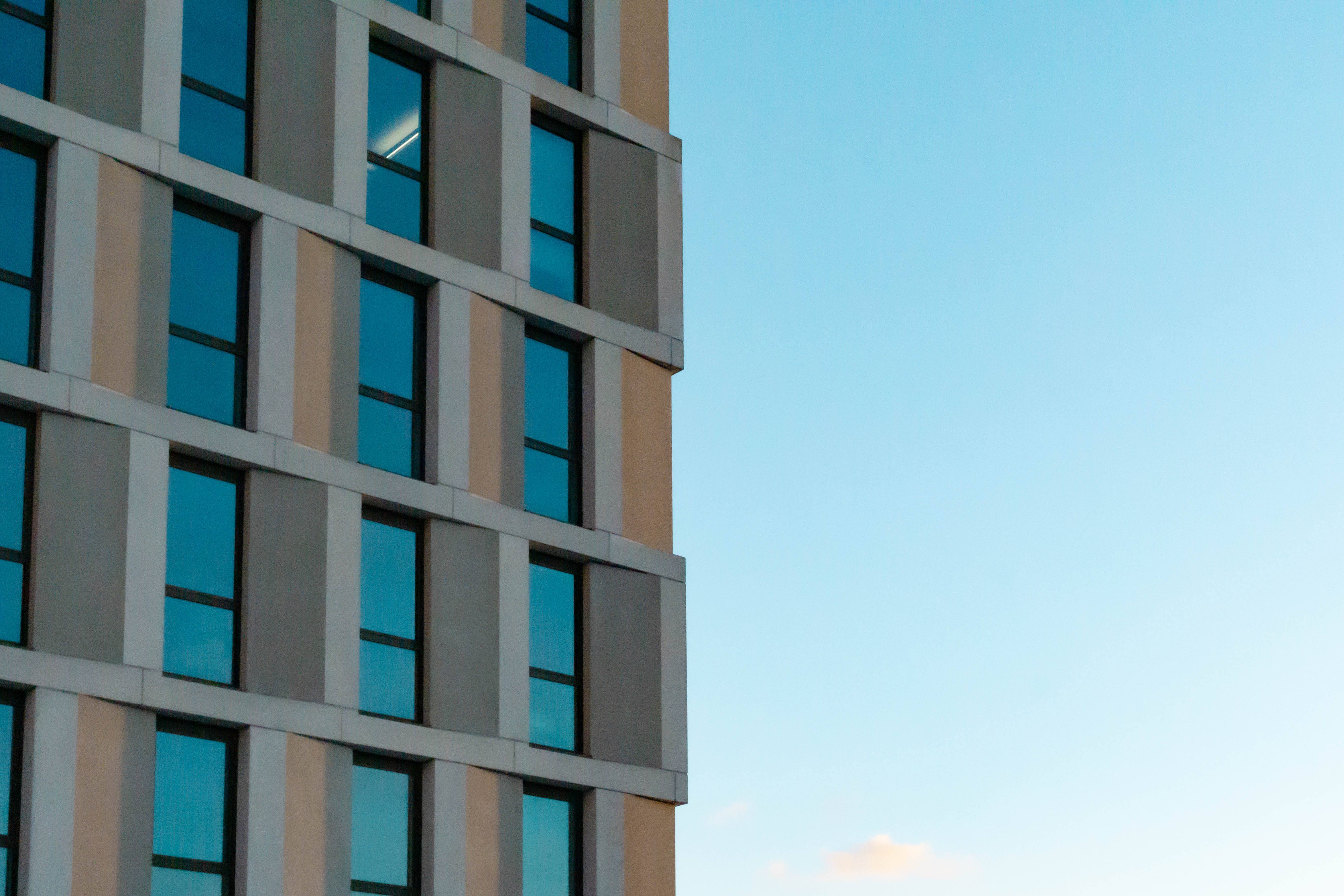 glassfront building with blue sky reflections