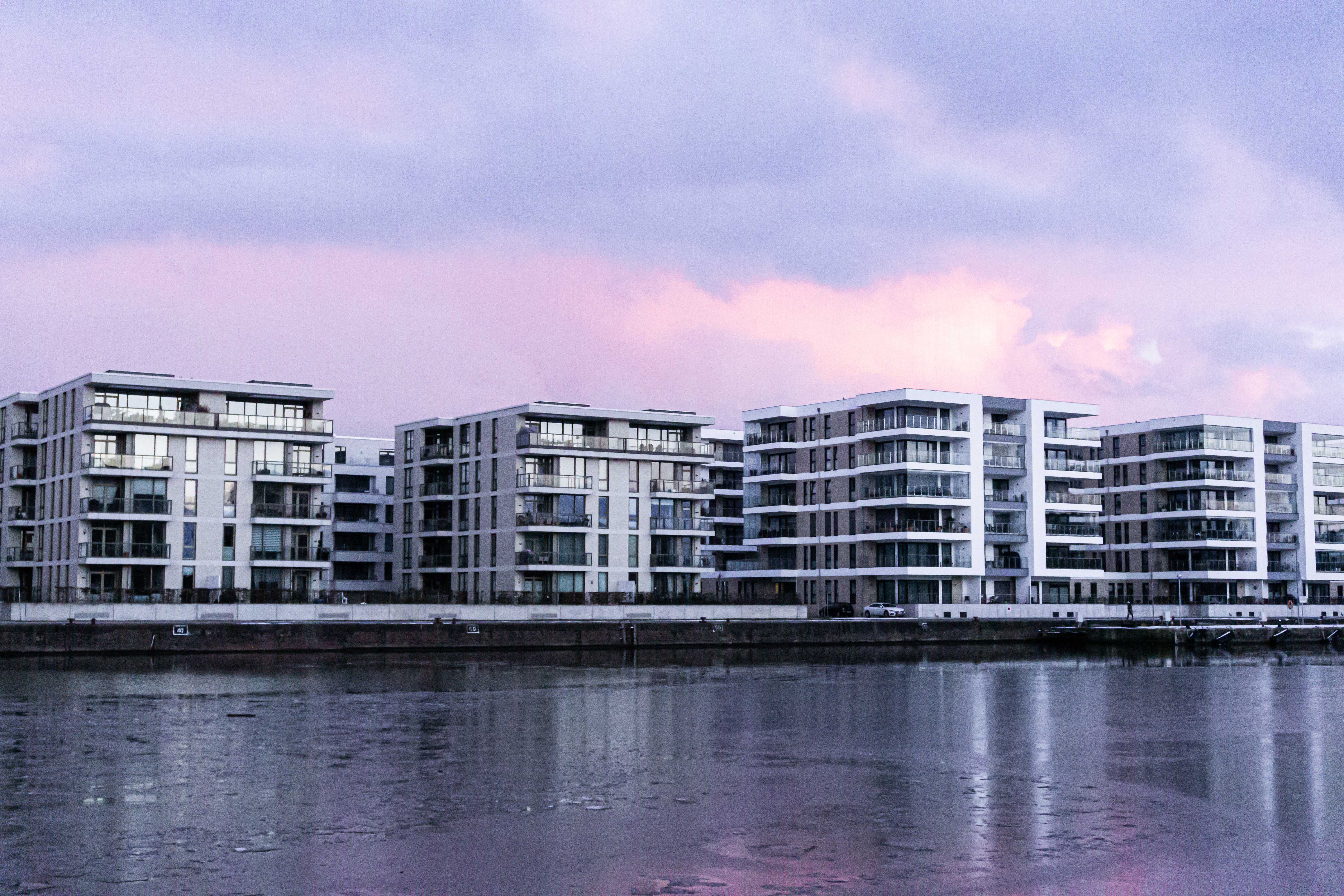 Buildings with huge glass windows under a pink-violett sky