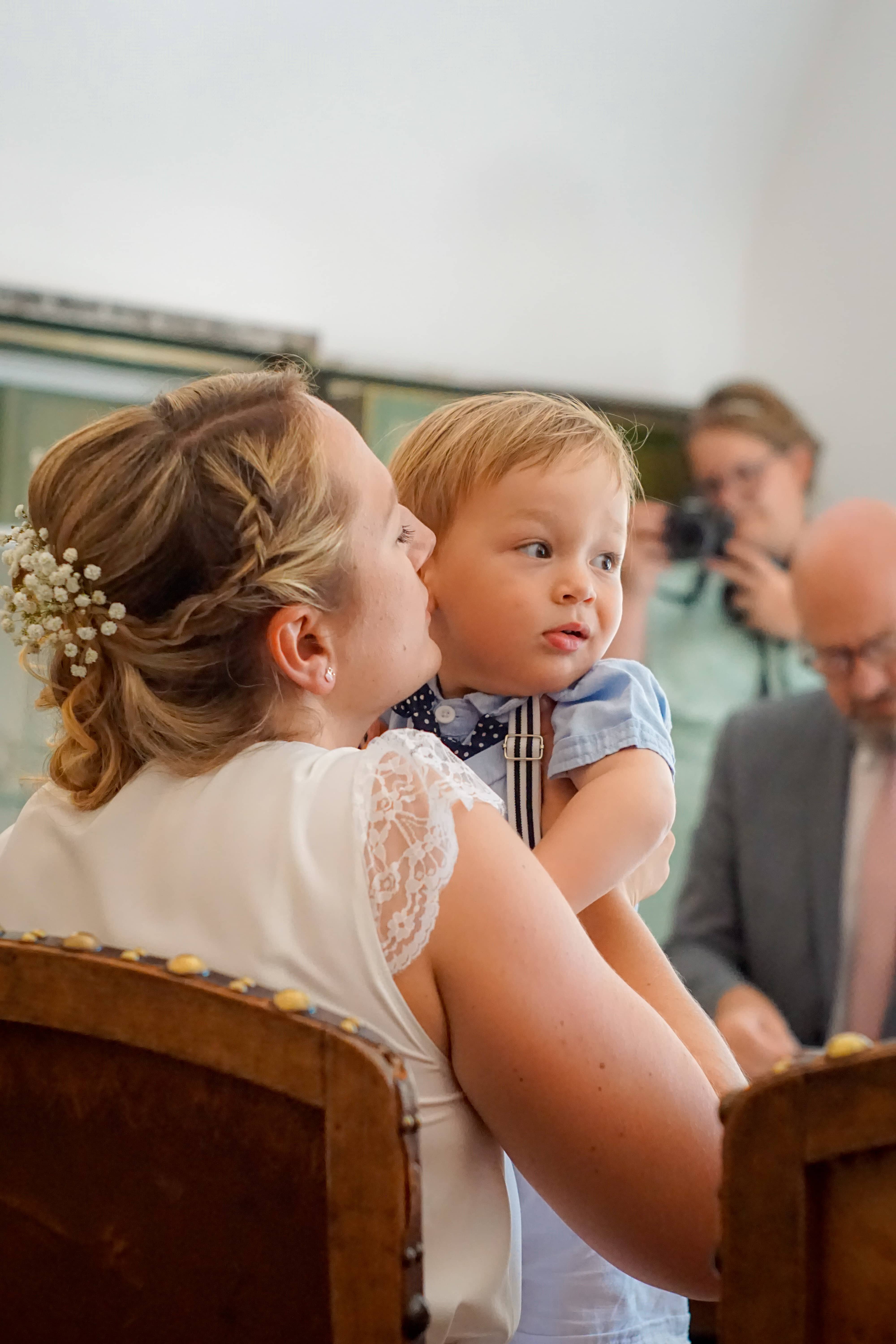 bride lifting her son to give him a kiss on the cheek