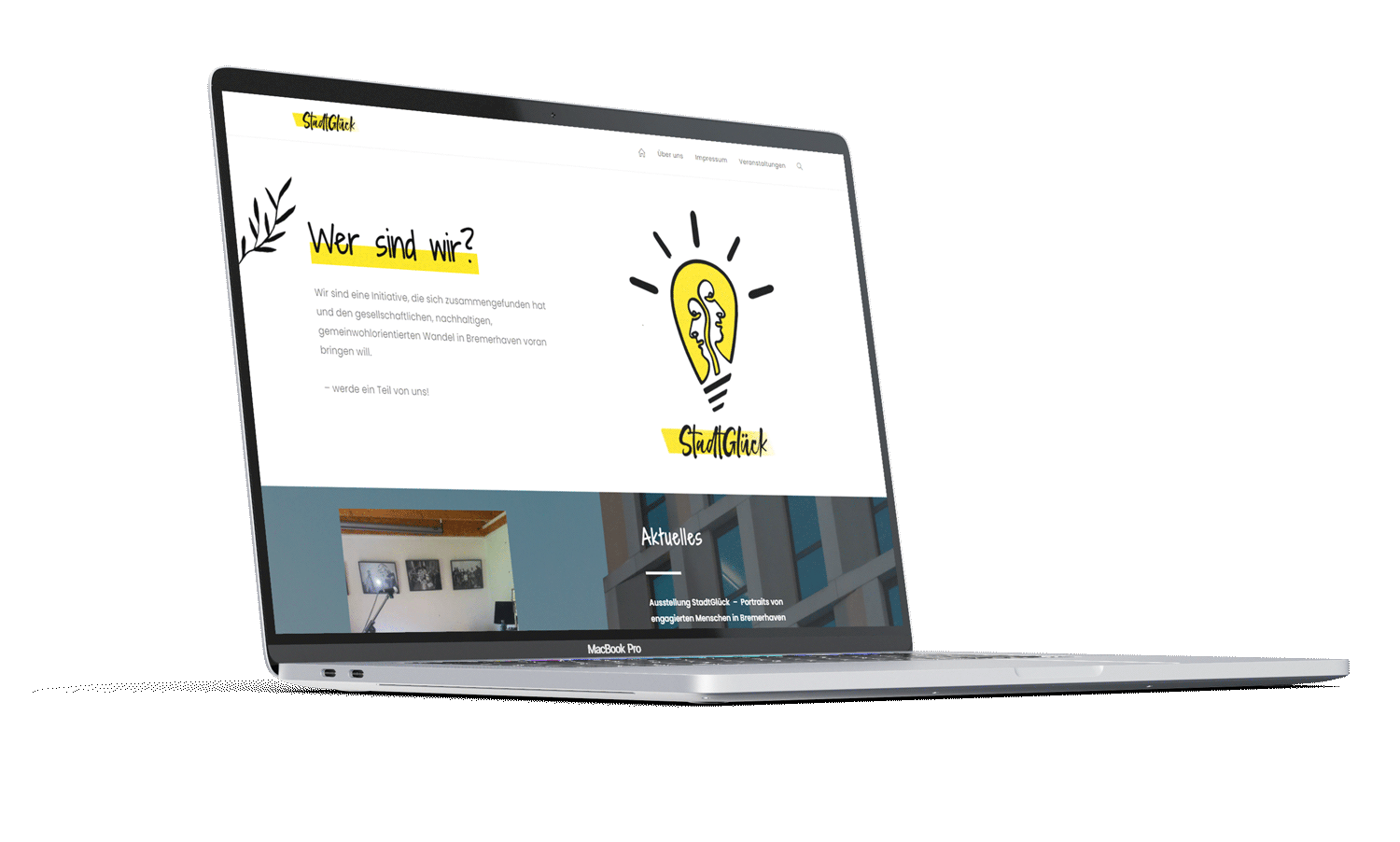 Mac Book screen with website 'StadtGlück bremerhaven' showing the landing page with a yellow Logo and some text